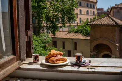 a plate of pastries and two cups on a balcony at Oasi artistica a Trastevere in Rome