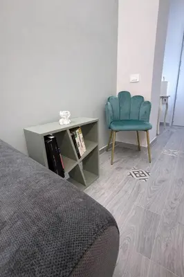 a bedroom with a blue chair and a table at Suite Maison San Pietro , Vaticano, AC & Wi-Fi in Rome