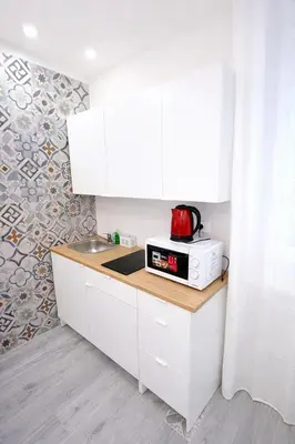 a kitchen with white cabinets and a microwave on a counter at Suite Maison San Pietro , Vaticano, AC & Wi-Fi in Rome