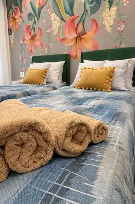 two beds with a pile of towels on them at Suite Maison San Pietro , Vaticano, AC & Wi-Fi in Rome