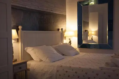 a bedroom with a white bed with a large mirror at Deluxe Vatican in Rome
