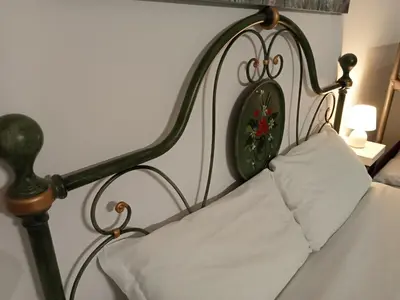 a bed with an ornate headboard with a white pillow at Deluxe Vatican in Rome