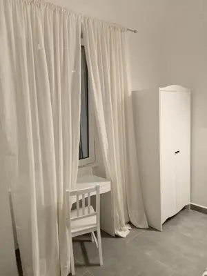 a white room with a chair and a window at Deluxe Vatican in Rome