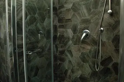 a shower with a glass door with a wooden floor at Deluxe Vatican in Rome