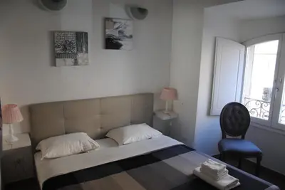 a bedroom with a bed and a chair and a window at Deluxe Vatican in Rome