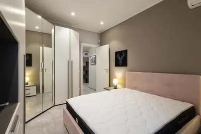 a bedroom with a large white bed and a mirror at Jmartins Vatican Apartment in Rome