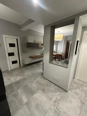 a living room with a large door and a kitchen at Jmartins Vatican Apartment in Rome