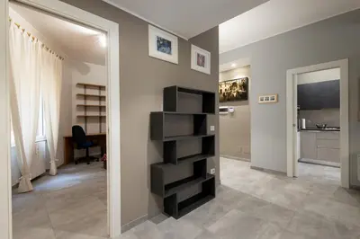 a living room with a black book shelf in the corner at Jmartins Vatican Apartment in Rome