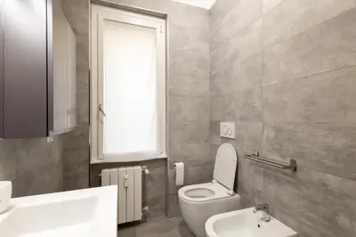 a bathroom with a toilet and a sink and a window at Jmartins Vatican Apartment in Rome