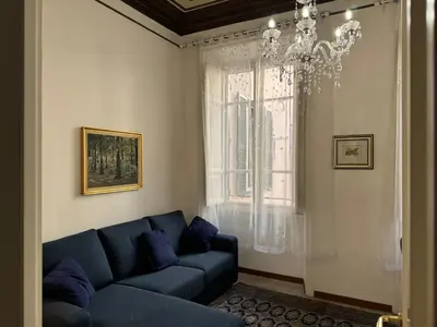 a living room with a blue couch and a chandelier at Casa Angeli in Rome