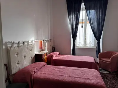 a hotel room with two beds and a window at Casa Angeli in Rome