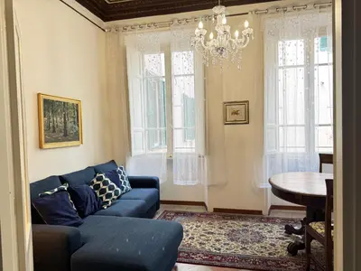a living room with a blue couch and a chandelier at Casa Angeli in Rome