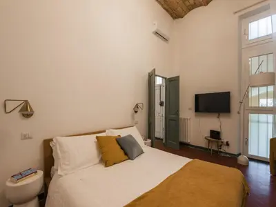 a bedroom with a bed and a toilet and a television at The Best Rent - Two-bedroom apartment in Santa Maria Maggiore in Rome