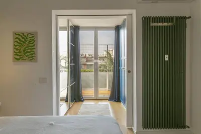 a bedroom with a bed and a door to a balcony at Luxe Vatican Penthouse in Rome