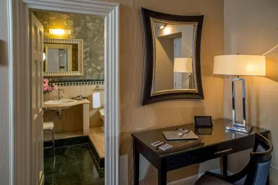 a bathroom with a desk and a sink and a mirror at The Inn at the Spanish Steps Luxury Collection - Suite Condotti in Rome