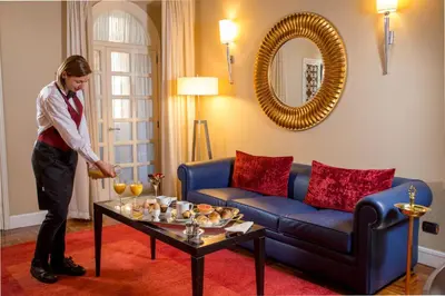 a man standing in a living room with a coffee table at The Inn at the Spanish Steps Luxury Collection - Suite Condotti in Rome