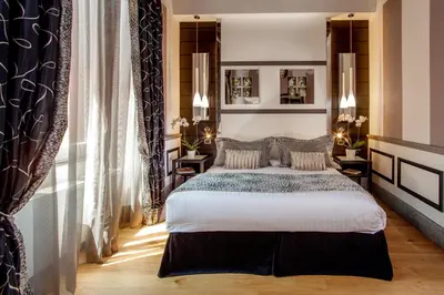 a bedroom with a large bed and two tables at The Inn at the Spanish Steps Luxury Collection - Suite Condotti in Rome