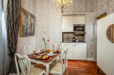 a kitchen and dining room with a table and chairs at The Inn at the Spanish Steps Luxury Collection - Bocca di Leone 63 Luxury Suites in Rome