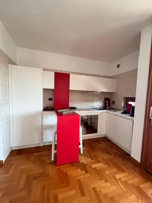 a kitchen with a red counter and a red table at Premium Apartment Papillo in Rome