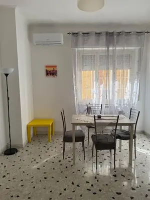 a dining room with a table and chairs and a window at Domus Romae Caffarella in Rome