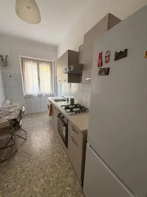 a kitchen with a refrigerator and a table in it at Domus Romae Caffarella in Rome