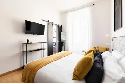 a bedroom with a bed and a flat screen tv at YCH-Charming home near San Giovanni in Rome