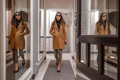 a woman walking down a hallway in front of mirrors at The Inn at the Spanish Steps Luxury Collection - Mario de' Fiori Home in Rome