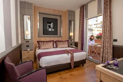 a hotel room with a bed and a person in the window at The Inn at the Spanish Steps Luxury Collection - Mario de' Fiori Home in Rome