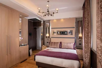 a bedroom with a bed and a chandelier at The Inn at the Spanish Steps Luxury Collection - Mario de' Fiori Home in Rome