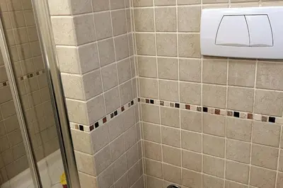 a tiled shower with a soap dispenser in a bathroom at A casa di Leo in Rome