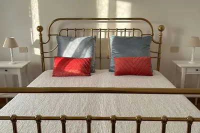 a bed with two red and grey pillows on it at A casa di Leo in Rome