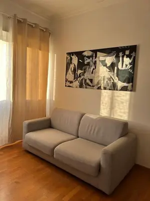 a couch in a living room with a painting on the wall at A casa di Leo in Rome