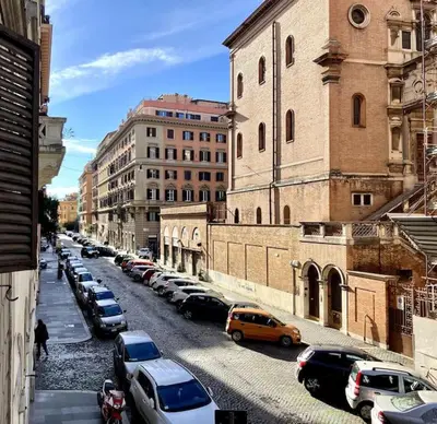 a city street filled with parked cars and buildings at Appartamento moderno a due passi dal Colosseo in Rome