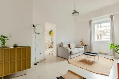 a white living room with a couch and a table at Appartamento moderno a due passi dal Colosseo in Rome