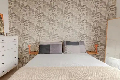 a bedroom with a bed and a wall at Appartamento moderno a due passi dal Colosseo in Rome