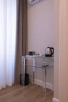 a glass table in the corner of a room at Tiburtina 86 Luxury Suites in Rome