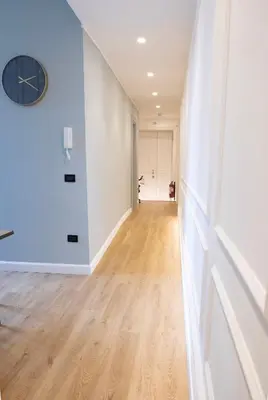 a hallway with white walls and a clock on the wall at Tiburtina 86 Luxury Suites in Rome