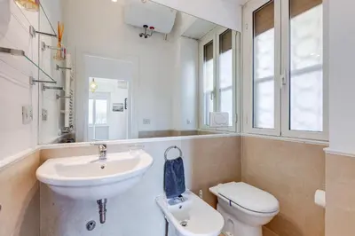 a white bathroom with a sink and a toilet at Chigi's Terrace in Rome