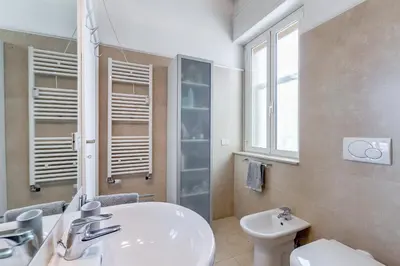 a bathroom with a sink and a toilet and a mirror at Chigi's Terrace in Rome