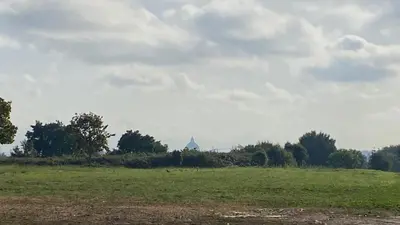 a green field with a building in the distance at Gemelli Flower's House in Rome