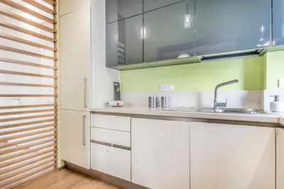 a kitchen with white cabinets and a sink at Alloggio Chigi in Rome