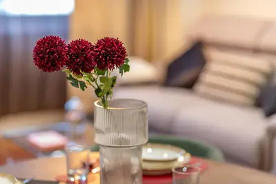a vase with red flowers sitting on a table at Villa Borghese Apartment in Rome