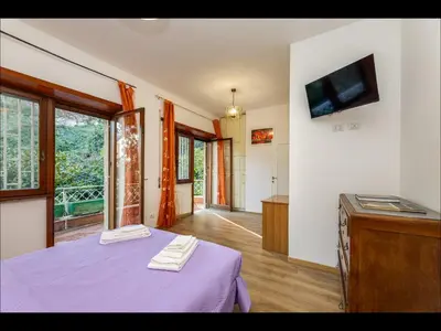 a bedroom with a purple bed and a tv on a wall at L aROMA ANTICA in Rome