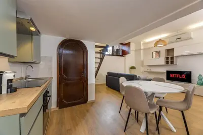 a kitchen and a living room with a table and chairs at Trastevere Experience in Rome