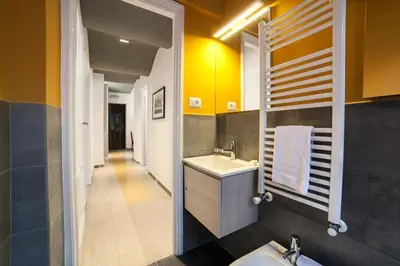 a bathroom with a sink and a toilet and a mirror at Monti 3 bedroom apartment Colisseum in Rome