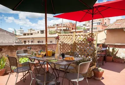 a patio with a table and chairs and umbrellas at Monti 3 bedroom apartment Colisseum in Rome