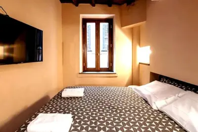 a bedroom with a bed and a tv and a window at Historic center apartment Rome in Rome