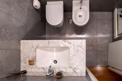 a bathroom with a white sink and two toilets at Historic center apartment Rome in Rome