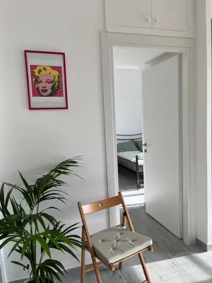 a wooden chair in a room with a plant at Paolettas House in Rome