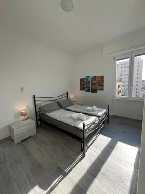 a bedroom with a bed and two windows at Paolettas House in Rome